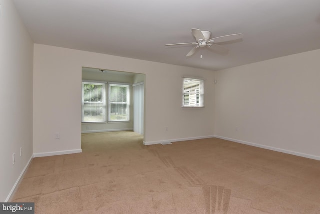 empty room with light colored carpet and ceiling fan