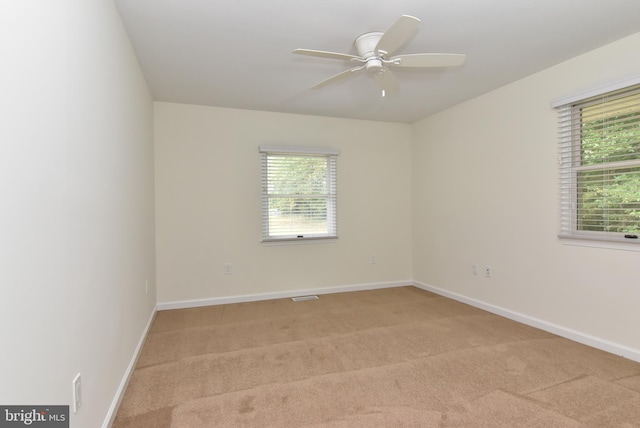 spare room featuring light carpet and ceiling fan