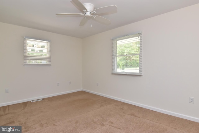 unfurnished room featuring light carpet, plenty of natural light, and ceiling fan