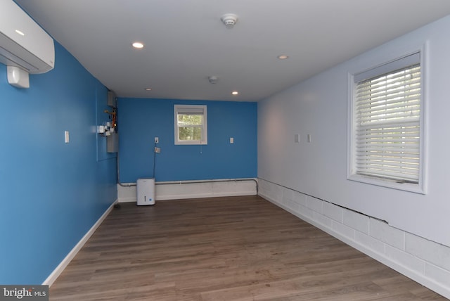 empty room featuring hardwood / wood-style floors and an AC wall unit