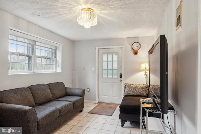 living room featuring a notable chandelier, a textured ceiling, and a wealth of natural light