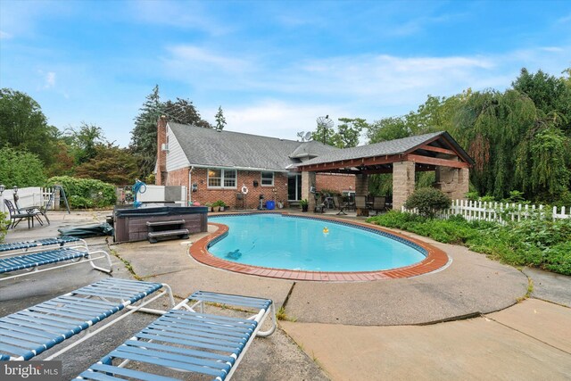 view of pool with a hot tub and a patio area