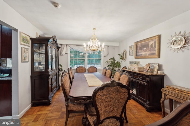 dining space featuring a chandelier and parquet floors