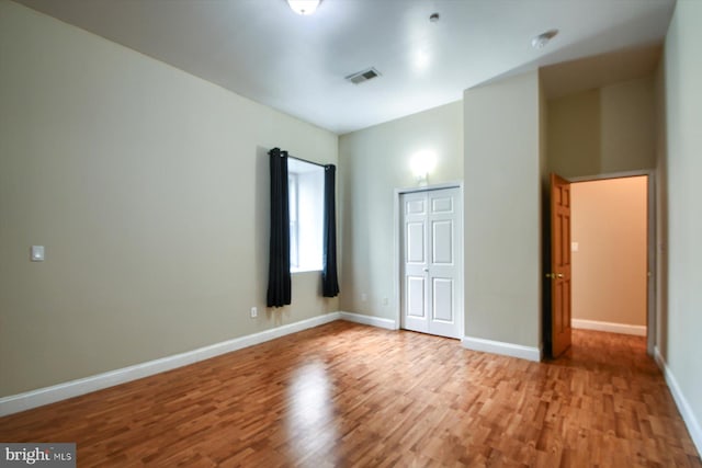 unfurnished bedroom with light wood-type flooring and a closet