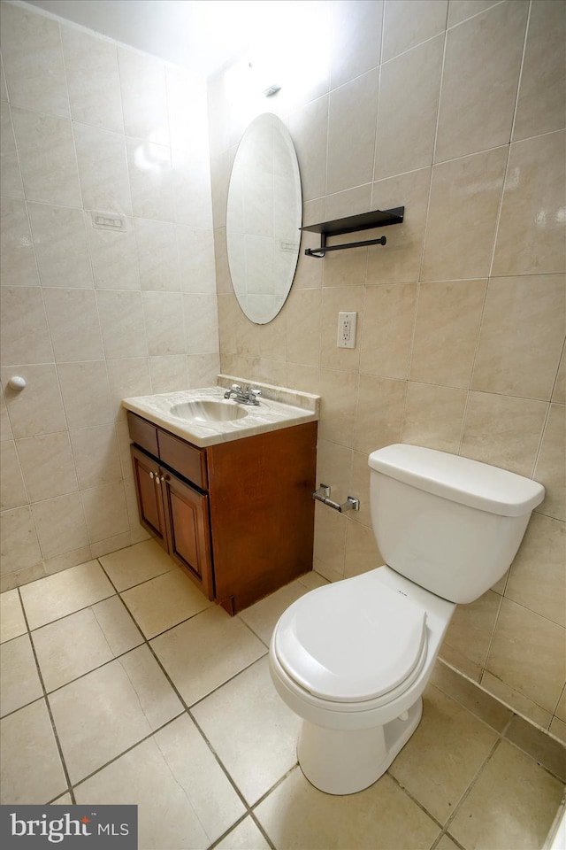 bathroom with tile walls, tile patterned flooring, vanity, and toilet