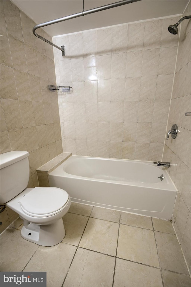 bathroom featuring tile walls, tile patterned flooring, toilet, and tiled shower / bath