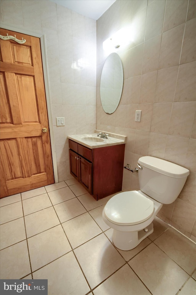 bathroom with tile walls, vanity, and toilet