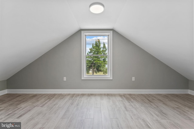 bonus room with lofted ceiling and light hardwood / wood-style floors