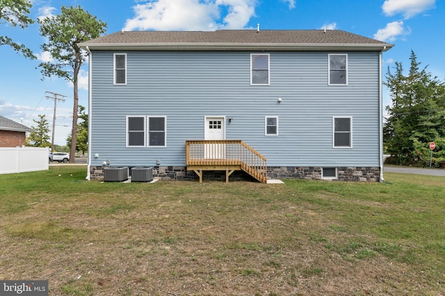 rear view of property with a lawn and central AC