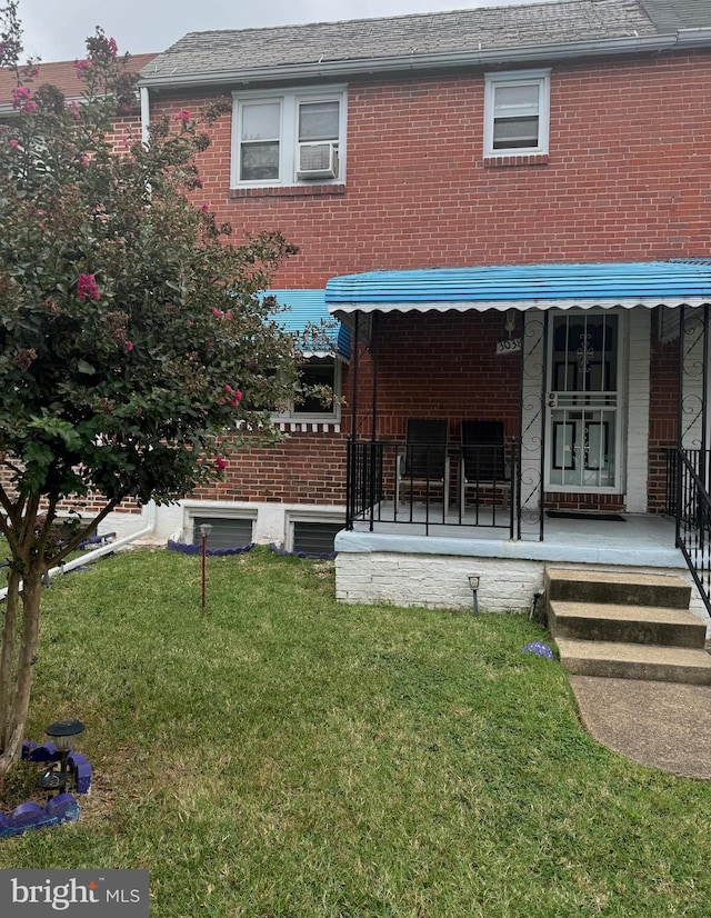 rear view of house featuring a yard