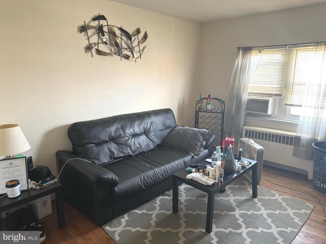 living room with cooling unit, radiator, and hardwood / wood-style floors