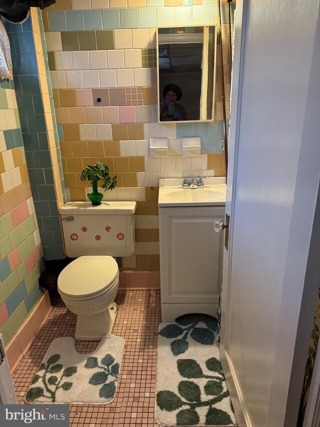 bathroom with tile walls, tile patterned floors, vanity, and toilet