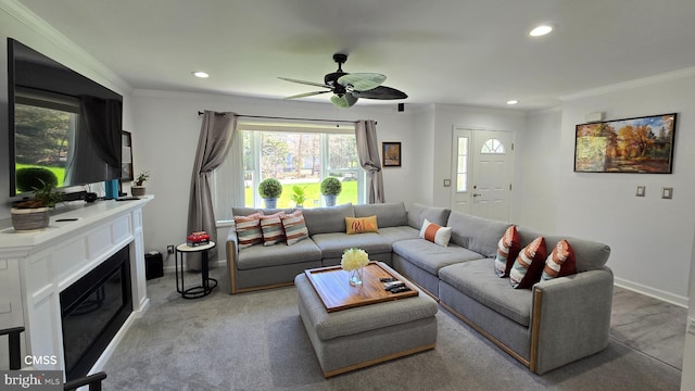 carpeted living room with ceiling fan and ornamental molding