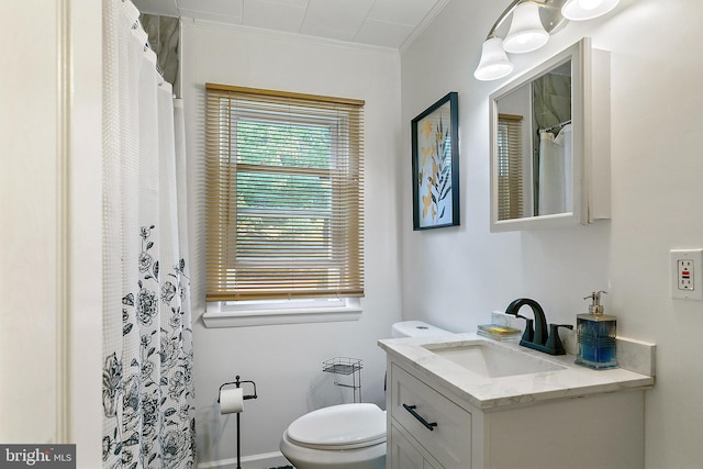 bathroom with vanity, crown molding, and toilet