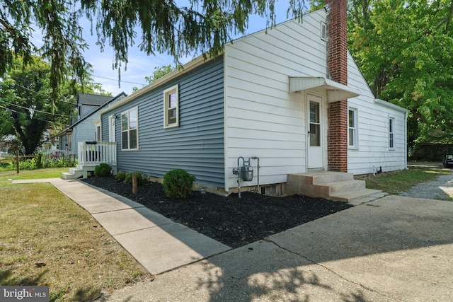 view of home's exterior featuring a lawn and a chimney