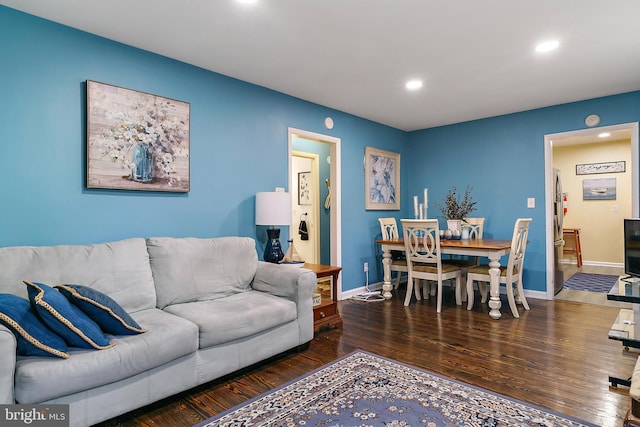 living room featuring baseboards, wood finished floors, and recessed lighting
