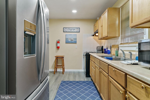 kitchen with light brown cabinets, sink, backsplash, hardwood / wood-style flooring, and stainless steel appliances