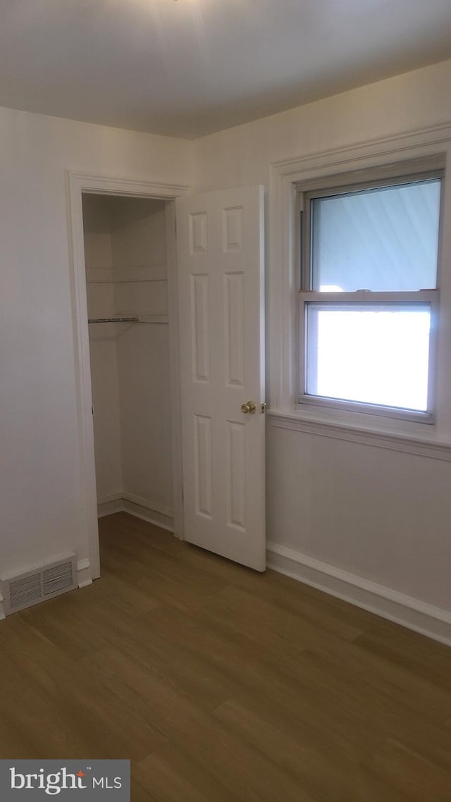 unfurnished bedroom featuring wood-type flooring and a closet