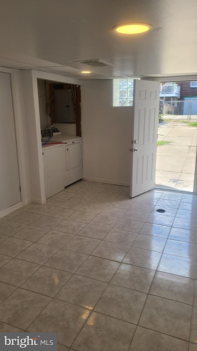 tiled entryway featuring washer and clothes dryer and electric panel