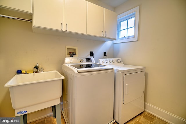 laundry area with sink, independent washer and dryer, and cabinets