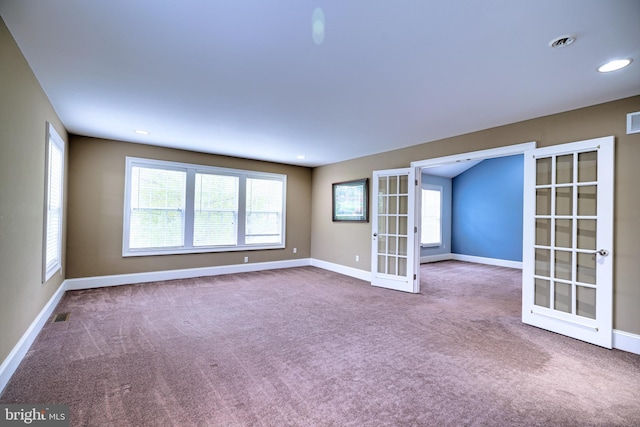 carpeted empty room featuring french doors