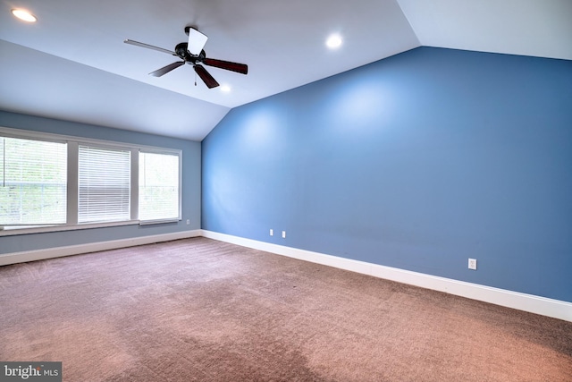 carpeted spare room with ceiling fan and vaulted ceiling