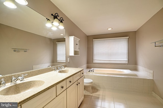 bathroom with vanity, tile patterned flooring, a relaxing tiled tub, and toilet