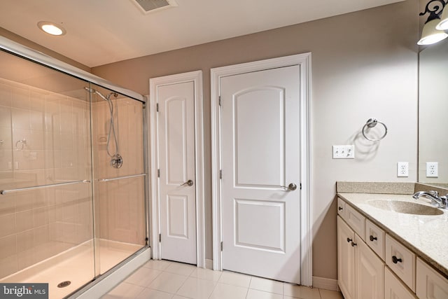 bathroom with walk in shower, tile patterned flooring, and vanity