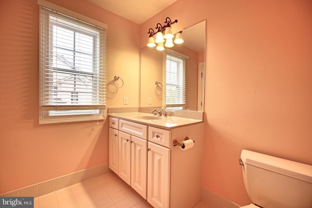 bathroom featuring tile patterned flooring, vanity, toilet, and plenty of natural light