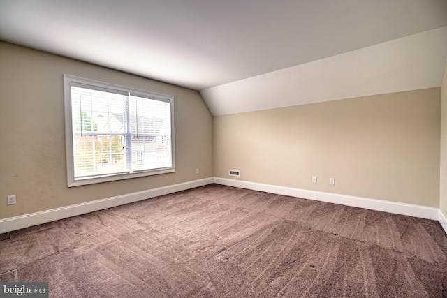 additional living space featuring vaulted ceiling and carpet floors