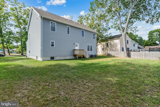 rear view of house with a lawn and central AC