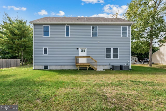 back of house featuring central AC unit and a yard