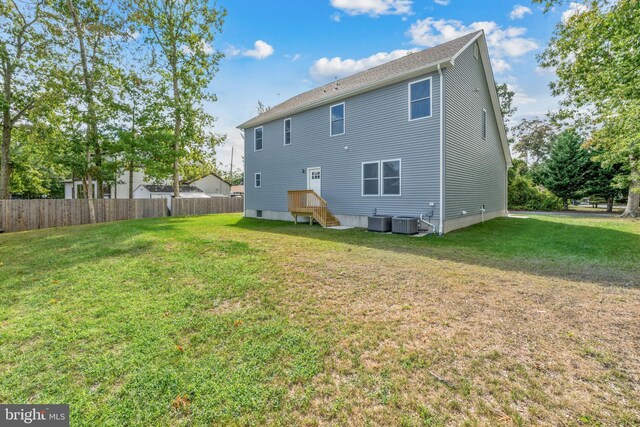 1406 Circle Dr, Forked River, NJ 08731 - rear view of house featuring cooling unit, fence, and a lawn
