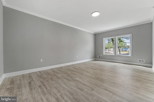 empty room with light hardwood / wood-style flooring and ornamental molding