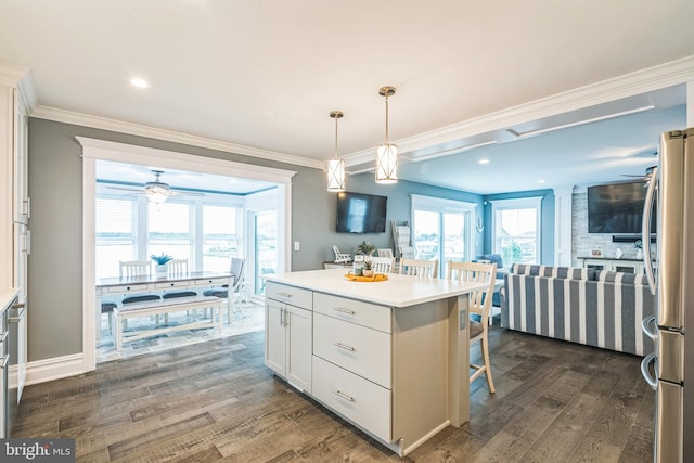 kitchen featuring white cabinetry, stainless steel refrigerator, dark hardwood / wood-style flooring, a center island, and decorative light fixtures