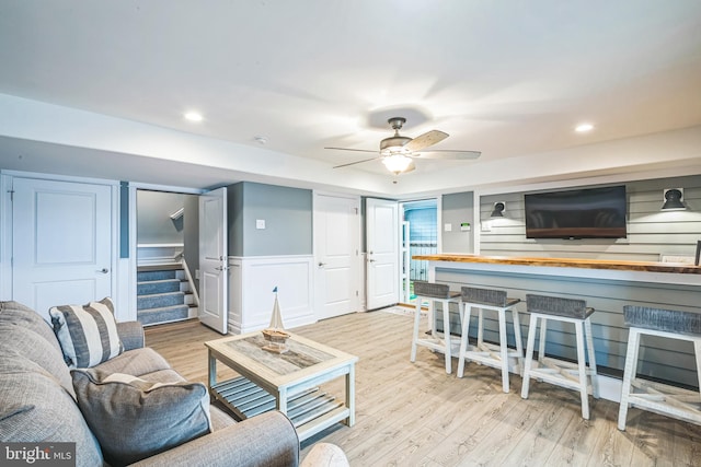 living room with light hardwood / wood-style floors and ceiling fan