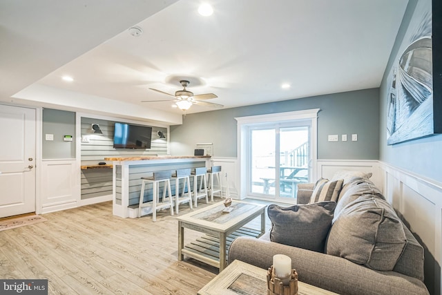 living room featuring light hardwood / wood-style floors and ceiling fan