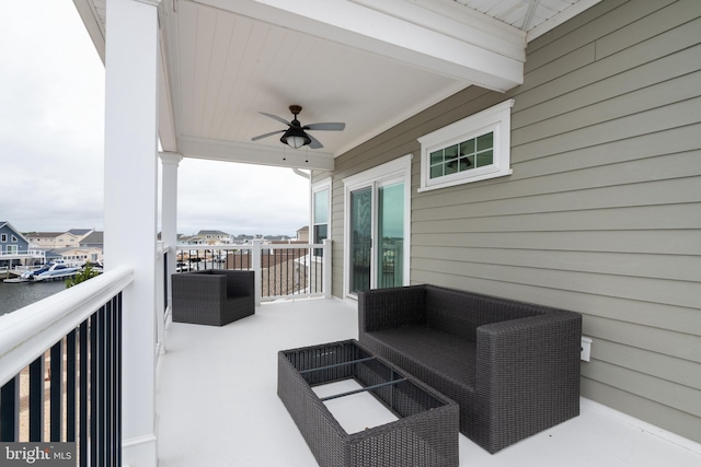 view of patio featuring a balcony, a water view, and ceiling fan