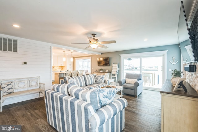 living room with ceiling fan and dark hardwood / wood-style flooring