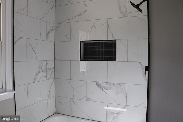 interior details with tiled shower / bath combo