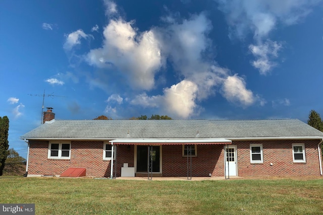 rear view of property featuring a lawn