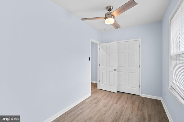 unfurnished bedroom featuring a closet, light wood-type flooring, and ceiling fan