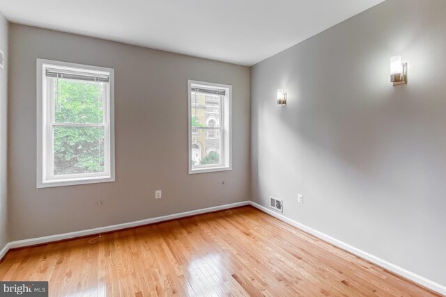 spare room with plenty of natural light and light hardwood / wood-style floors