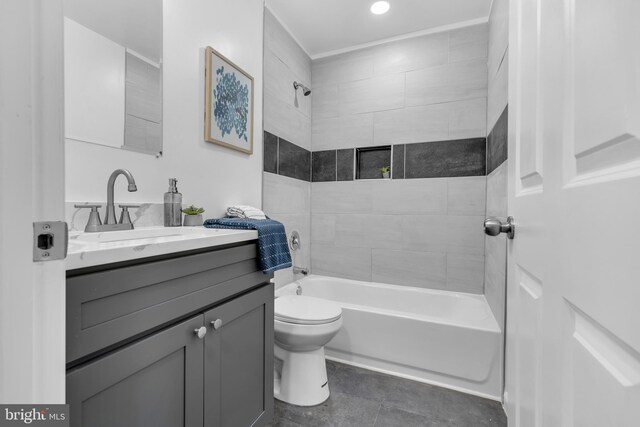 full bathroom featuring tiled shower / bath, vanity, and toilet