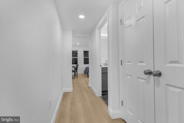 corridor featuring light hardwood / wood-style floors and sink