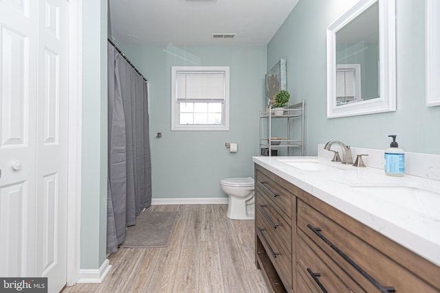 bathroom featuring vanity, toilet, and hardwood / wood-style flooring