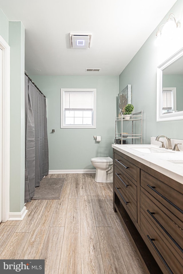 bathroom featuring vanity, hardwood / wood-style floors, and toilet