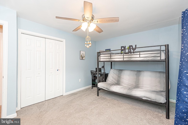 carpeted bedroom featuring ceiling fan and a closet