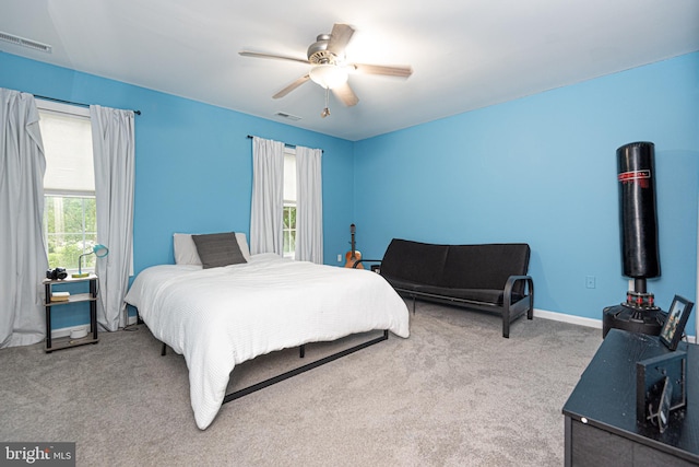 bedroom with multiple windows, ceiling fan, and light colored carpet