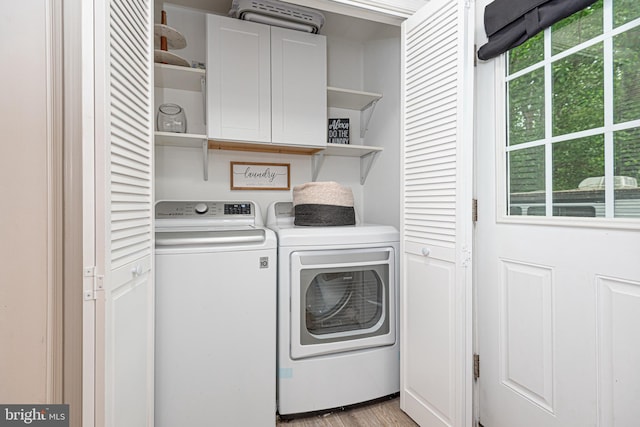 washroom featuring cabinets, light hardwood / wood-style floors, and separate washer and dryer